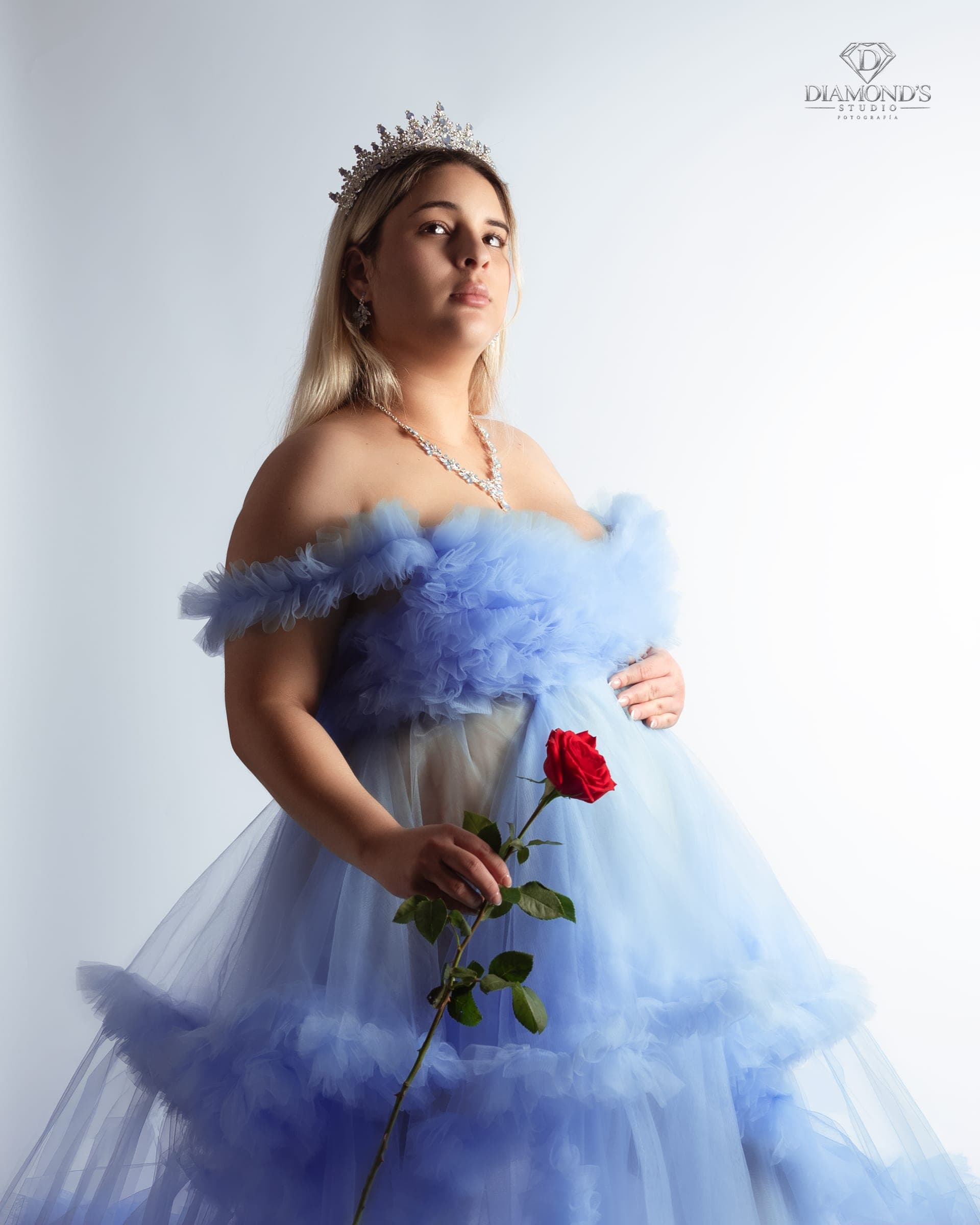 Maternity session: blue tulle gown holding a red rose