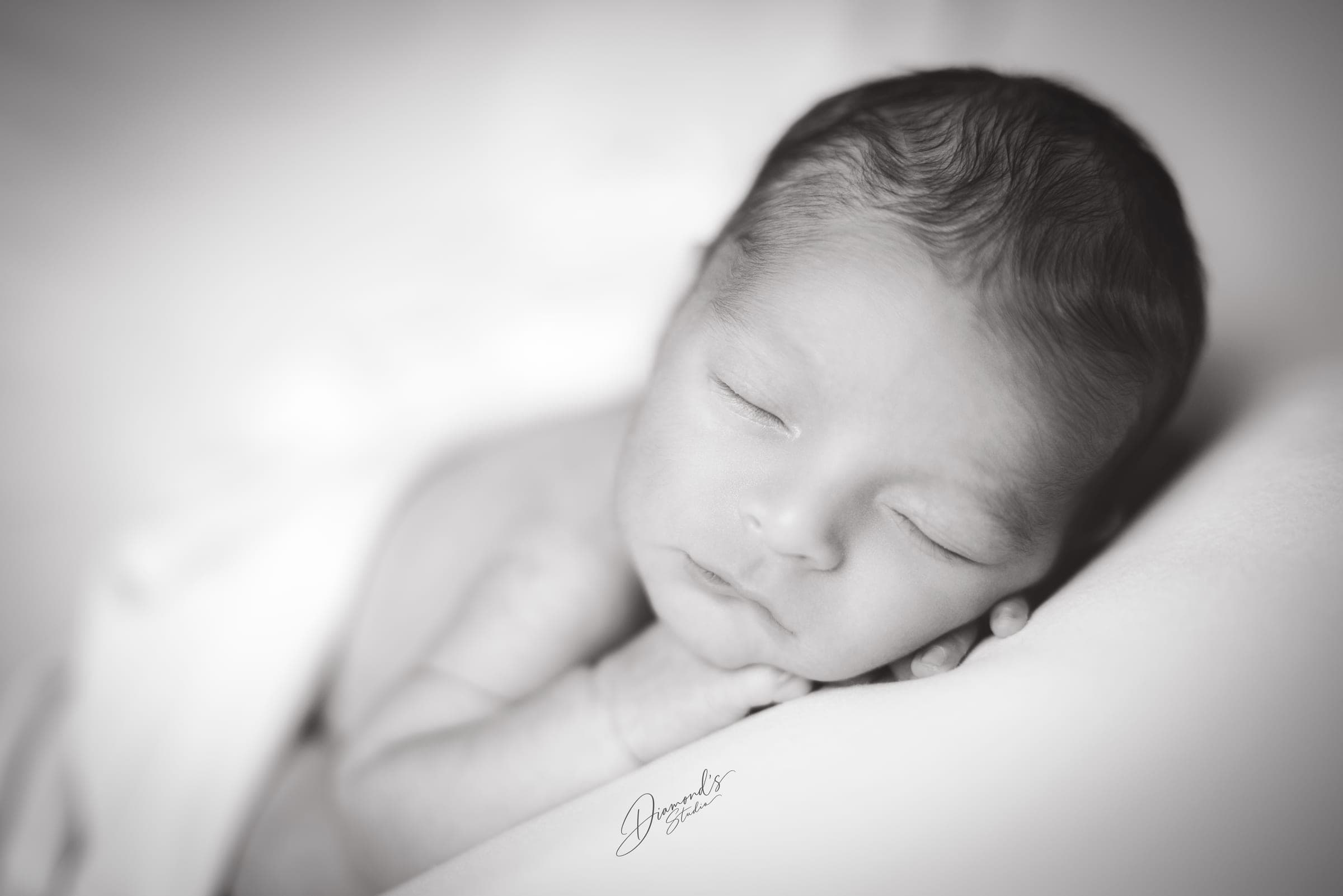 Sesión newborn: primer plano del recién nacido dormido, en blanco y negro